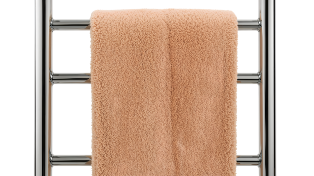 Soft peach towel hanging on chrome heated towel rail in modern minimalist bathroom interior, fresh and cozy home decor accent