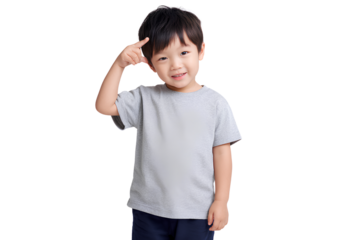 A photo of an Asian boy in a gray short-sleeved T-shirt and navy blue pants, smiling with one hand pointing to his head while standing against a transparent background