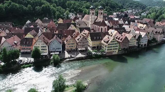 Aerial shot of a European town with timbered buildings and river running beside it