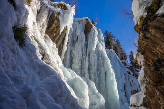 Winter ice climbing crag in the Alps. Imst Pitztal area famous for its frozen waterfalls in winter. Huge ice stalactites hanging on the wall of a canyon in the Alps. Winter ice climbing extreme sports