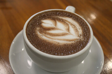Hot Chocolate with Detailed Latte Art on a Wooden Table