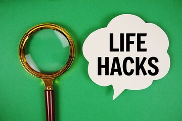 Life Hacks text with speech bubble and magnifying glass on green background
