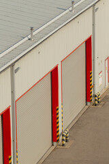 A large building featuring numerous garage doors and a substantial roof structure that covers the...