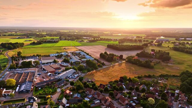 Beautiful golden light of sunset colors the scenery of the town. Drone footage over the countryside in the Netherlands.