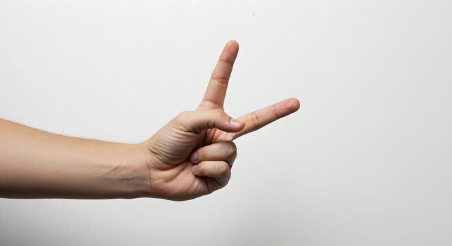 Human hand gesturing victory symbol with fingers extended upward and outward for positive message with white background