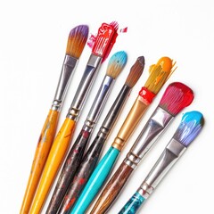 Fototapeta premium Assorted paintbrushes with colorful paint splatters on white background