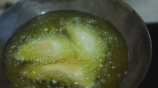 Gujhiya a dessert being crispy fried in oil