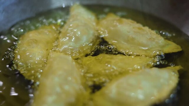 Gujhiya a dessert being crispy fried in oil