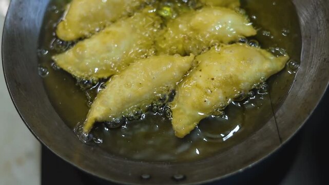 Gujhiya a dessert being crispy fried in oil