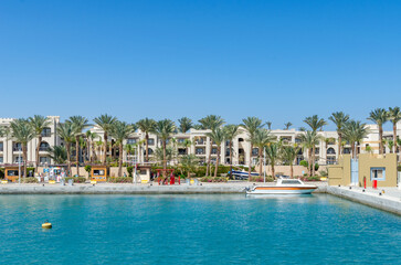 Resort buildings with palm trees along the turquoise waterfront in Port Ghalib, Egypt 10 March 2025