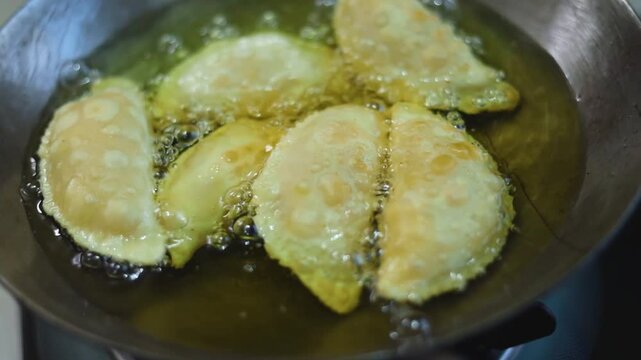 Gujhiya a dessert being crispy fried in oil