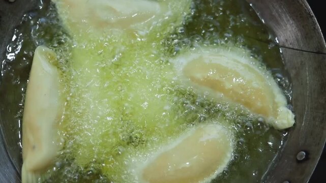 Gujhiya a dessert being crispy fried in oil