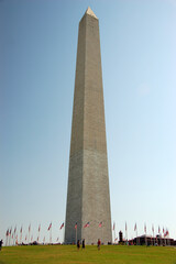 Obraz premium The Washington Monument, an iconic marble obelisk on the National Mall in Washington, D.C., honoring George Washington, surrounded by U.S. flags