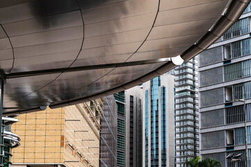 Futuristic canopy structure leading into a vertical pattern of financial district highrises in Kuala Lumpur, Malaysia