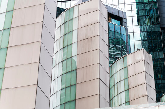 Soft-toned architectural forms with green glass and mirrored reflections in Kuala Lumpur, Malaysia