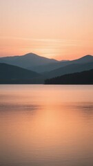 Fototapeta premium Calm Lake at Sunset with Silhouetted Mountains