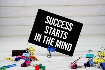 Success Starts In The Mind text on paper card with stationary on wooden background