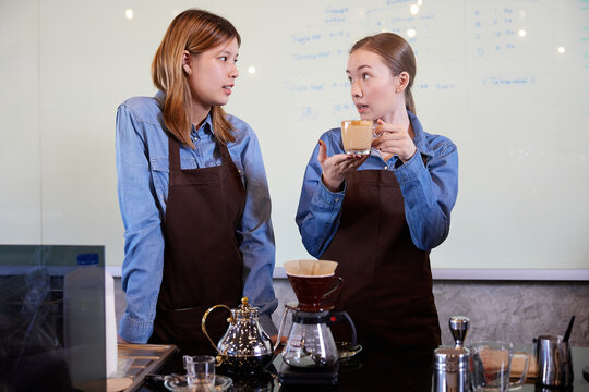 young barista woman making fresh coffee from machine and checking quality in the cafe
