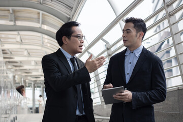 Business investors in suits stand outside the building discussing investment plans and business expansion plans to achieve their goals