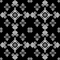 A black and white patterned design featuring intricate geometric shapes and motifs, creating a visually striking textile appearance.