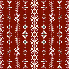 A decorative pattern featuring intricate white designs on a rich red background, creating a visually striking textile motif.