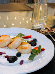 Delicious dessert plated with fresh fruits, cream, and a refreshing drink in a modern setting