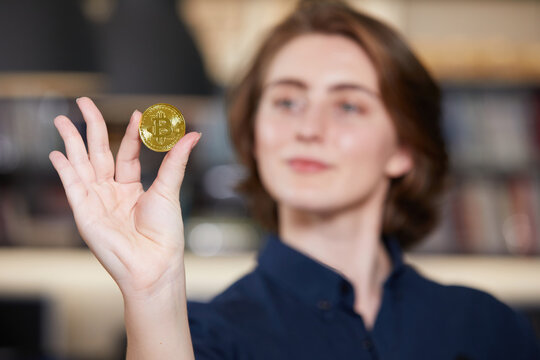 close up businesswoman holding and showing golden bitcoin cryptocurrency on hand - Powered by Adobe
