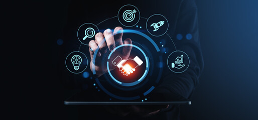 Digital handshake and business strategy concept with icons for innovation, target, analytics, growth, and teamwork on dark tech background.