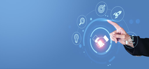 Business technology concept showing digital handshake, partnership icons, and innovation symbols on futuristic blue background with hand interaction.