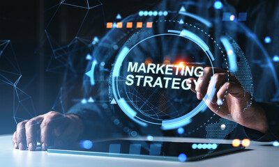 Marketing strategy digital concept with futuristic interface and human hands interacting with tablet on dark tech-themed background.