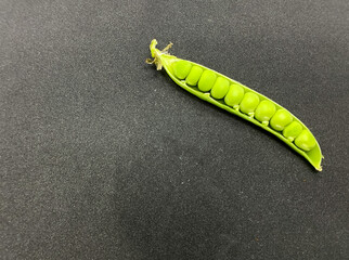 Pea pods and a pile of peas (snap pea,sugar snap pea)