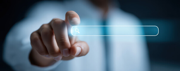 Person using a digital search interface with a glowing search bar in a modern, technology-focused environment