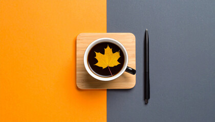 Coffee Leaf in Autumn: An overhead shot presents a cup of coffee with a leaf resting on a wooden coaster, and a pen on a table, autumn concept and the beauty of simplicity