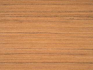 Teak wood veneer surface with warm golden hues interlaced with rich brown grain lines