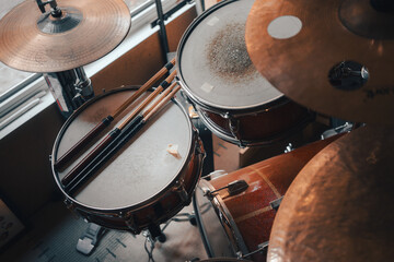 An old drum set in the room by the window
