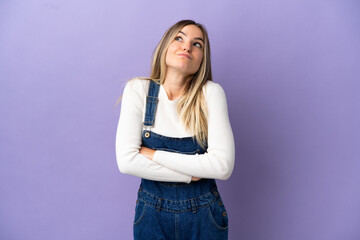 Young woman over isolated purple background making doubts gesture while lifting the shoulders