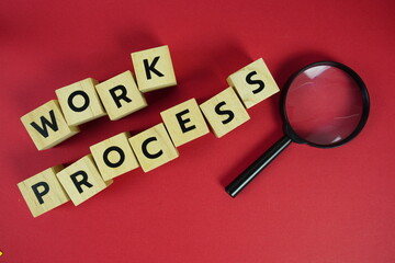 Work Process alphabet letters with magnifying glass flat lay on red background