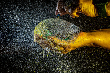 Globo de agua estallándose en las manos con fondo oscuro n/2