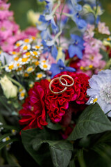 Two Wedding Rings on a Red Flower Bouquet