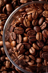 Close-Up of Roasted Coffee Beans in a Glass Bowl, Roasted coffee beans in glass bowl on dark background. Close up.