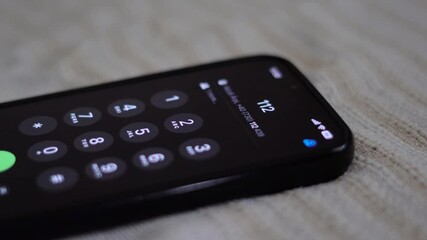 Man in need of help dialling 112 emergency number on smartphone.