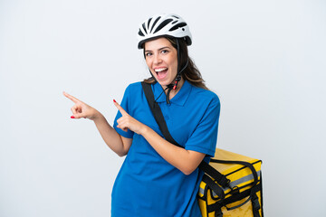 Young delivery woman with thermal backpack isolated on white background surprised and pointing side