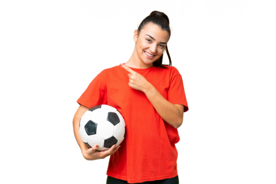 Young beauty woman over isolated chroma key background with soccer ball and pointing to the lateral
