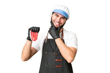 Butcher man wearing an apron and serving fresh cut meat over isolated chroma key background happy and smiling