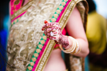 hands of a bride covered with henna tattoo and wedding ring on her finger ready for Indian wedding,...