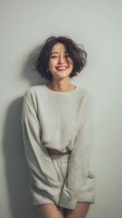 Studio Portrait of a korean young woman, soft natural lightning, casual outfit, light grey background, realistic photograph