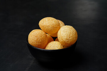 Delicious north and south indian street food pani puri gol gappa with tamarind water served in black bowl © Black Spade Design