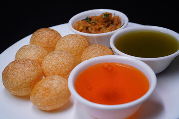 Delicious north and south indian street food pani puri gol gappa with tamarind water served in white plate and potato and chickpeas © Black Spade Design