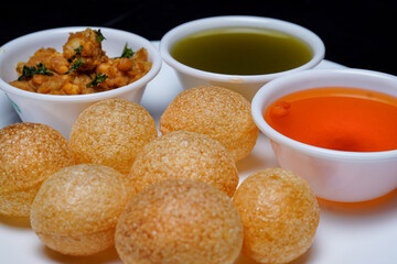 Delicious north and south indian street food pani puri gol gappa with tamarind water served in white plate and potato and chickpeas © Black Spade Design