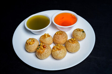 Delicious north and south indian street food pani puri gol gappa with tamarind water served in white plate and potato and chickpeas © Black Spade Design